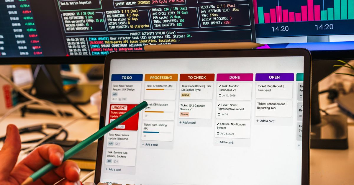 Detailed view of a business workflow setup with tablet and multiple screens displaying data charts.