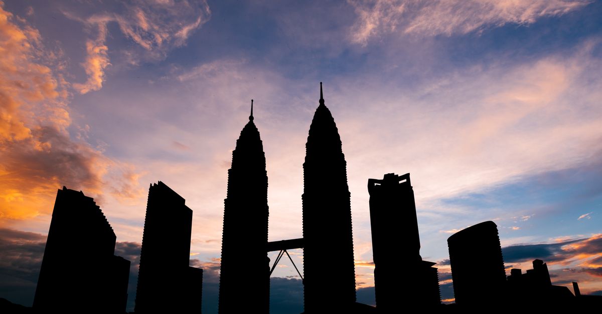 Cloud Infrastructure for Startups: A Practical Guide for Kuala Lumpur Entrepreneurs Stunning silhouette of Kuala Lumpur's Petronas Towers against a vibrant sunset sky.