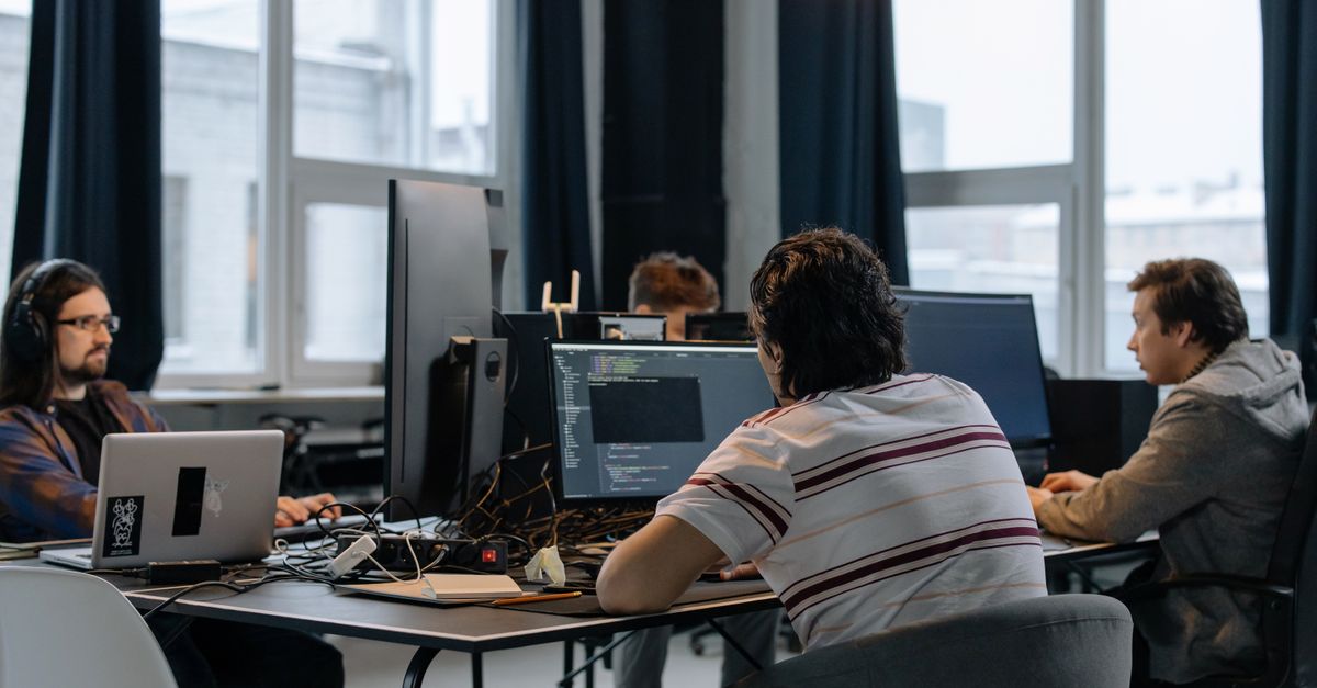 Custom Software & Mobile App Development Services in New York, USA – Expert Guide Team of developers working together on computers in a modern tech office.