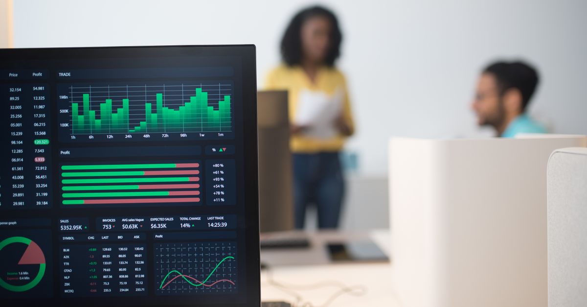 Modern office with financial trading screens and a diverse team discussing strategies.