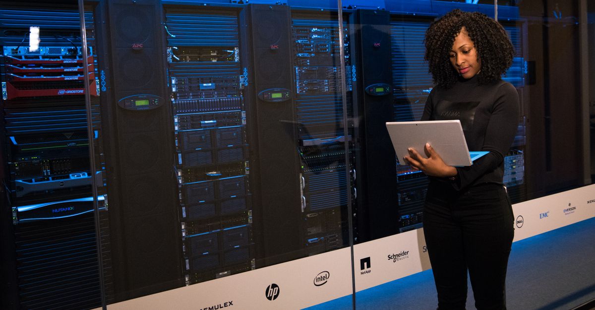 Expert IT Infrastructure Consulting in Kuala Lumpur, Malaysia – Cloud Solutions Guide A female engineer using a laptop while monitoring data servers in a modern server room.