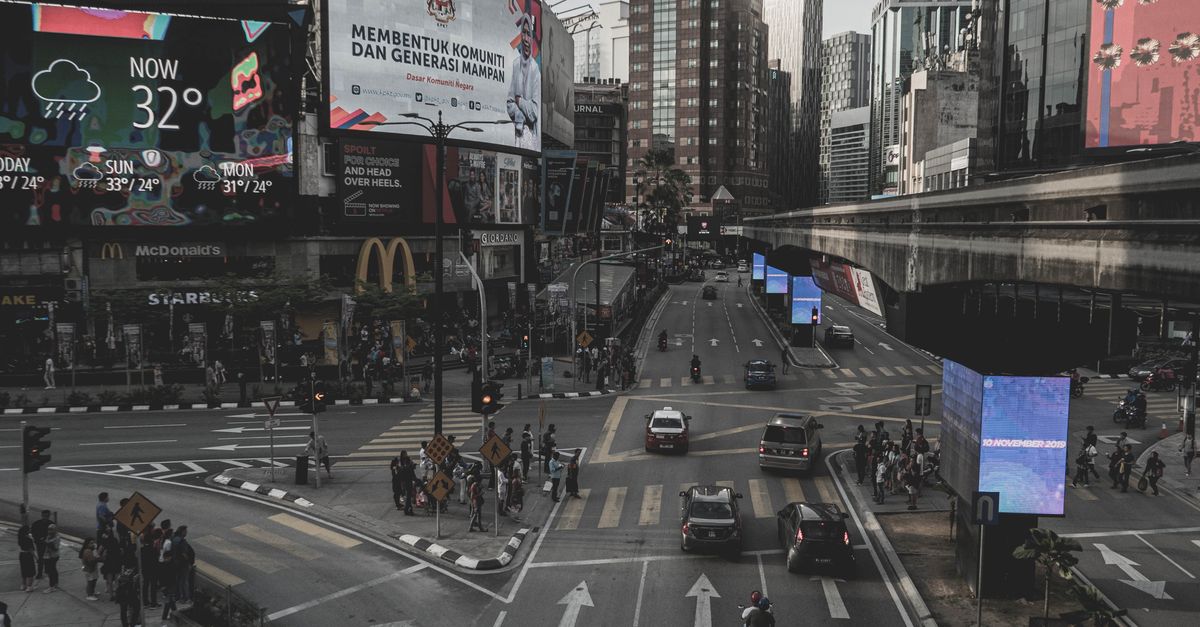Rank on Google and Get Cited by AI: Proven Strategies for Kuala Lumpur Businesses City street view of Kuala Lumpur showcasing traffic and billboards under a cloudy sky.
