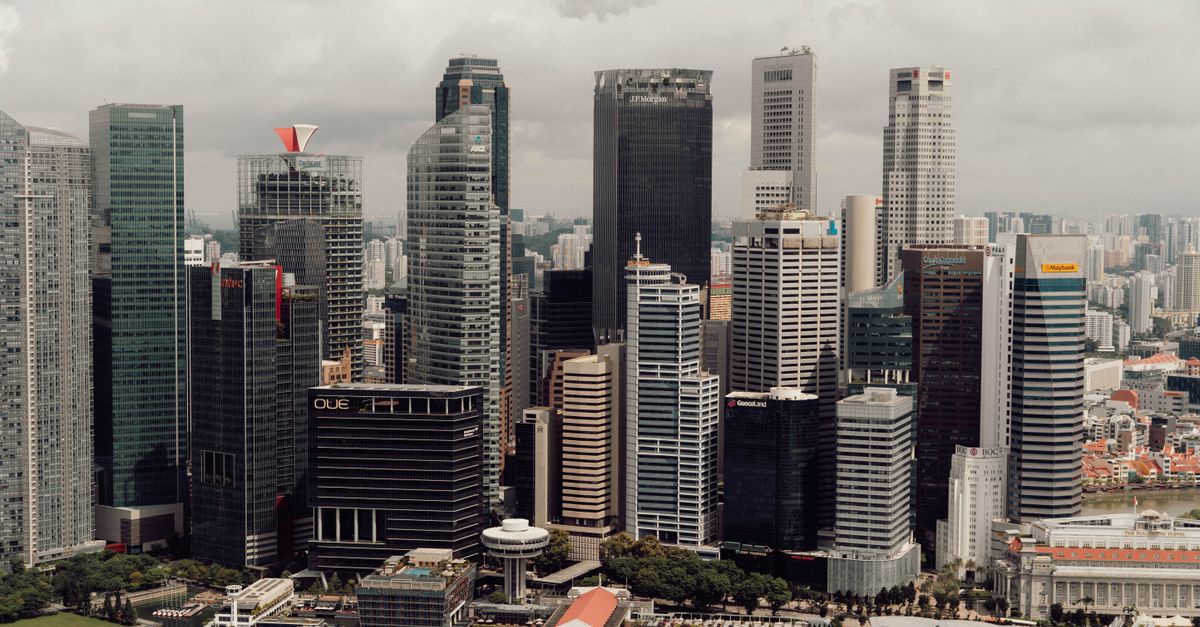 Rank on Google and Get Cited by AI: SEO, GEO & AEO Guide for Singapore City Center Aerial view of Singapore's modern skyline with iconic skyscrapers and waterfront.