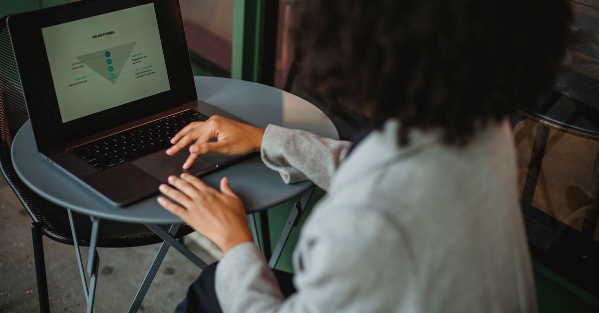 Sites Built to Convert: Expert Web Design & Development in London, UK Back view of anonymous ethnic female in suit working with chart on computer while sitting at table in outdoor cafe during remote work