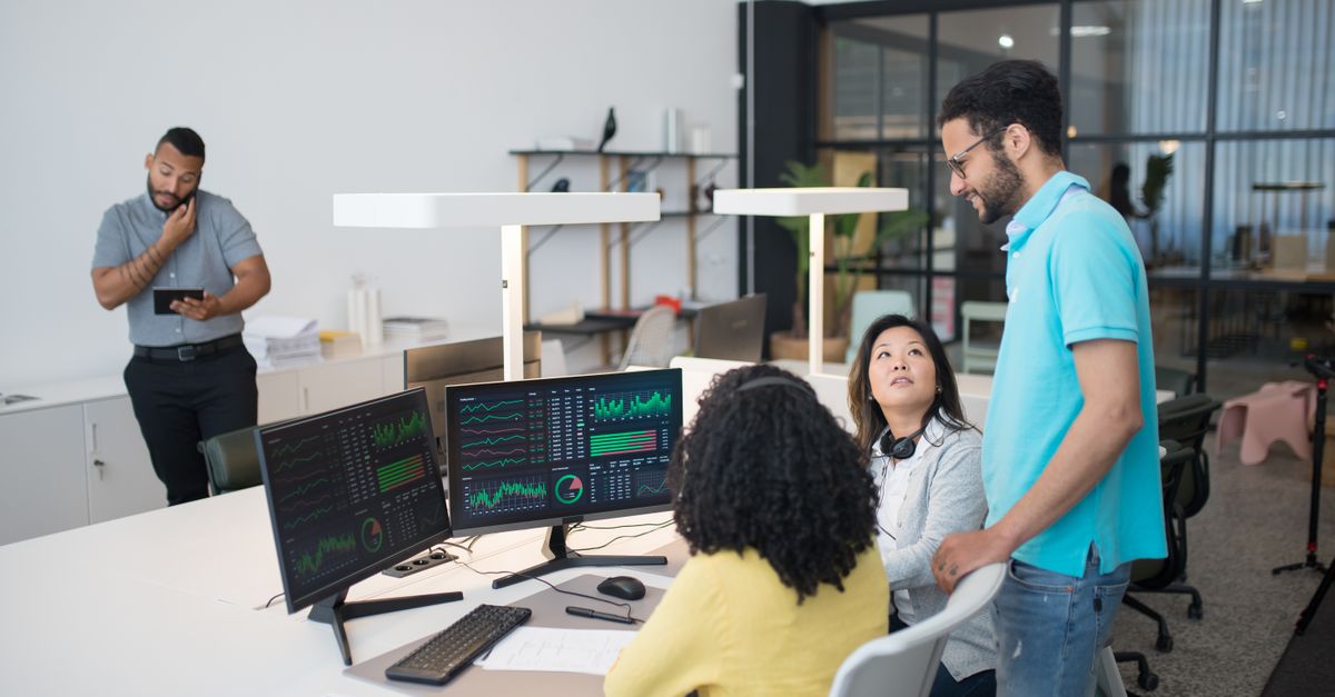 Stop Doing Repetitive Work: AI Workflow Automation Guide for City Center, Singapore Office employees collaborate on financial data at modern workspace, engaging in teamwork and communication.