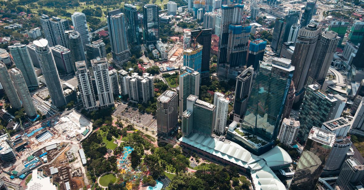 Stop Doing Repetitive Work: AI Workflow Automation Guide for Kuala Lumpur Businesses Stunning aerial view of a bustling cityscape filled with modern skyscrapers and lush greenery.